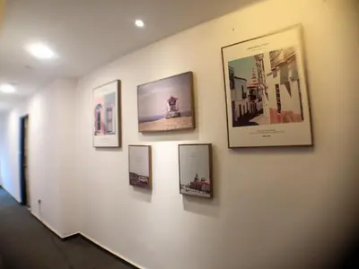 a wall with framed pictures on a wall at M Design Hotel @ Taman Pertama in Kuala Lumpur