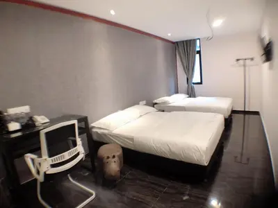 a hotel room with two beds and a chair in it at M Design Hotel @ Taman Pertama in Kuala Lumpur