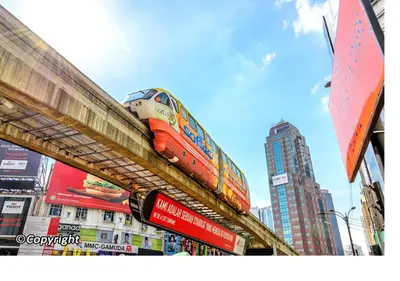 a train on top of a bridge in a city at Bukit Bintang Apartment by Sarah's Lodge @ Fahrenheit88 in Kuala Lumpur