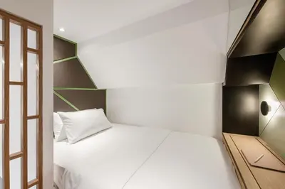 a small bedroom with a white bed and a window at Komune Living in Kuala Lumpur