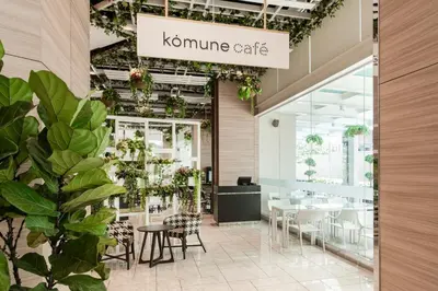 a restaurant with tables and chairs and plants at Komune Living in Kuala Lumpur