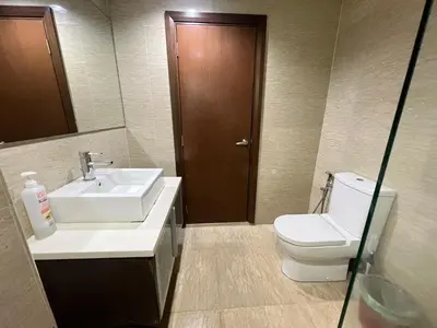 a bathroom with a sink and a toilet and a mirror at Regalia suites & residence 2 bedroom apartment by Enjoy your stay in Kuala Lumpur