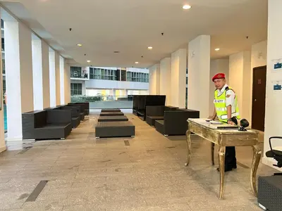 a man standing next to a table in a building at Regalia suites & residence 2 bedroom apartment by Enjoy your stay in Kuala Lumpur