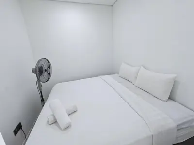 a bedroom with a white bed with a fan at Yemala Suites at Vortex KLCC in Kuala Lumpur