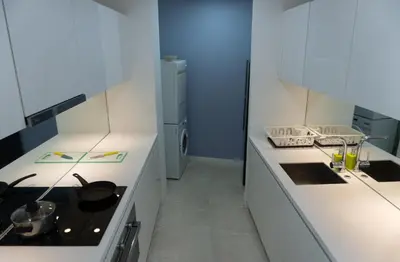 a kitchen with white counters and a stove top oven at Yemala Suites at Vortex KLCC in Kuala Lumpur