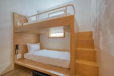 a bunk bed with a staircase in a room at MoMo's Kuala Lumpur in Kuala Lumpur