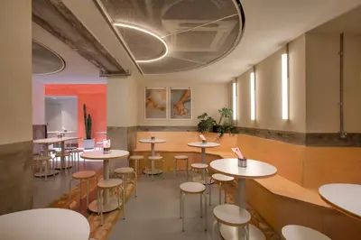a room with tables and stools in a restaurant at MoMo's Kuala Lumpur in Kuala Lumpur