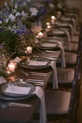 a row of tables with plates and candles and flowers at The Chow Kit - an Ormond Hotel in Kuala Lumpur