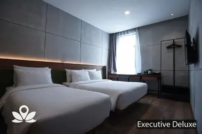 a hotel room with two beds and a television at Ceria Hotel in Kuala Lumpur