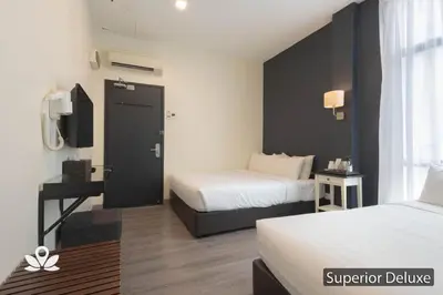 a hotel room with two beds and a door at Ceria Hotel in Kuala Lumpur