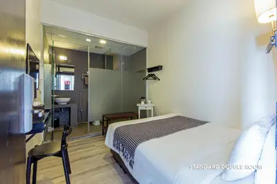 a bedroom with a bed and a bathroom with a mirror at Ceria Hotel in Kuala Lumpur