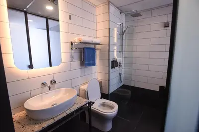 a white bathroom with a sink and a toilet at Ceria Hotel in Kuala Lumpur