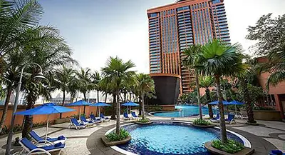a resort with a pool with chairs and palm trees at Rihanna service suite at times square in Kuala Lumpur