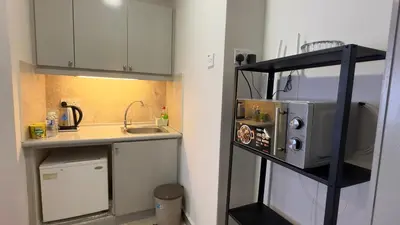 a small kitchen with a sink and a microwave at Rihanna service suite at times square in Kuala Lumpur