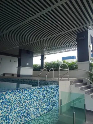 a swimming pool in a building with a blue tile floor at VUE RESIDENCES SERVICE SUITE 2 ROOMS DELUXE 6 Pax in Kuala Lumpur