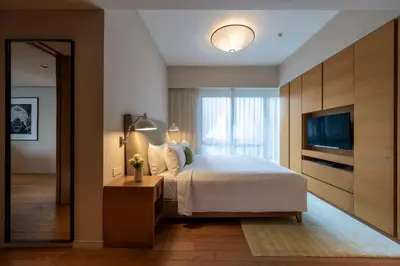 a bedroom with a large bed and a television at Lanson Place Bukit Ceylon in Kuala Lumpur