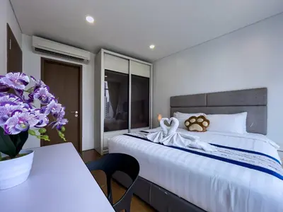 a bedroom with a bed and a table with purple flowers at Vortex Suites KLCC by BlackNest in Kuala Lumpur