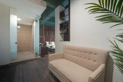 a living room with a couch and a bedroom at East Riverine Boutique Hotel in Kuala Lumpur
