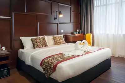 a hotel room with a large bed with a swan on it at East Riverine Boutique Hotel in Kuala Lumpur