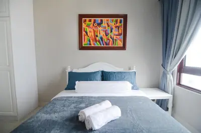 a bedroom with a bed with two towels on it at Rafflesia Condominium by Dahlia Homes in Kuala Lumpur