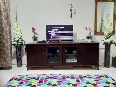 a living room with a flat screen tv on a cabinet at UMMII Homestay in Ampang