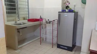 a kitchen with a refrigerator next to a sink at UMMII Homestay in Ampang