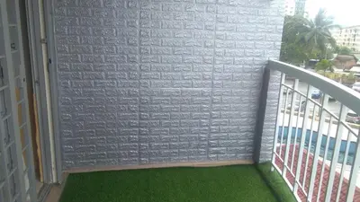 a balcony with green flooring and a brick wall at UMMII Homestay in Ampang