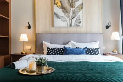 a bedroom with a bed with a green blanket and blue pillows at TriBeCa 2bedroom 3min walk to bukit bintang 2 rooftop pool in Kuala Lumpur