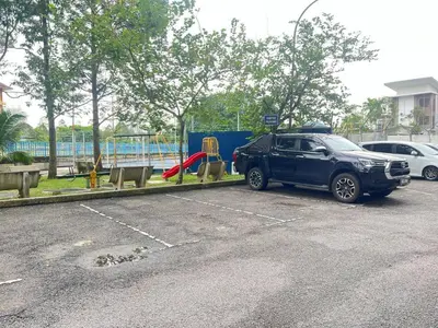 a car parked in a parking lot next to a playground at Mahasa Homestay Kuala Lumpur in Kuala Lumpur