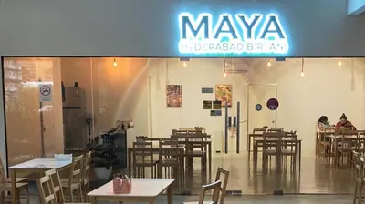 a restaurant with tables and chairs and a sign at 3 Towers 10min to KLCC next to Hospital Gleneagle in Kuala Lumpur