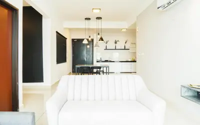 a living room with a white couch and a table at Boulevard Service Apartment KL by Airhost in Kuala Lumpur