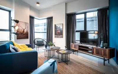 a living room with a blue couch and a tv at Arte Plus Jalan Ampang by Airhost in Kuala Lumpur