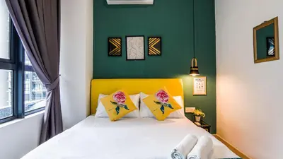 a bedroom with a bed with a yellow headboard at Arte Plus Jalan Ampang by Airhost in Kuala Lumpur