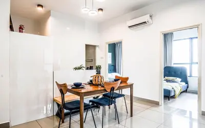 a kitchen and dining room with a wooden table and chairs at Arte Plus Jalan Ampang by Airhost in Kuala Lumpur