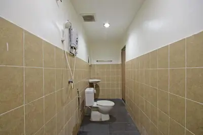 a bathroom with a toilet and a phone on the wall at Hotel O Shalimar in Kuala Lumpur