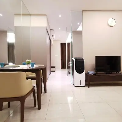 a living room with a tv and a table and a refrigerator at Sky Pool Elegant Suite @ Sri Hartamas in Kuala Lumpur