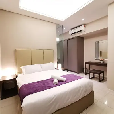 a bedroom with a bed with a white towel on it at Sky Pool Elegant Suite @ Sri Hartamas in Kuala Lumpur
