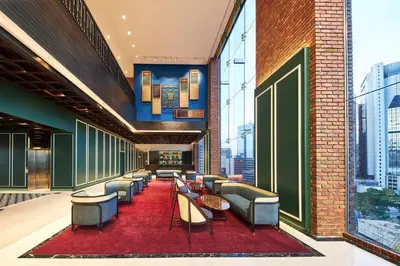 a lobby with chairs and tables on a red rug at Four Points by Sheraton Kuala Lumpur, Chinatown in Kuala Lumpur