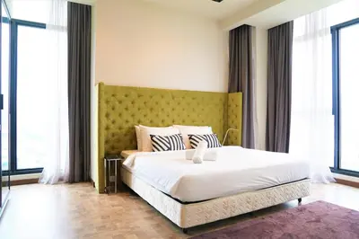 a bedroom with a large white bed and large windows at ExpressionZ Suites KLCC in Kuala Lumpur
