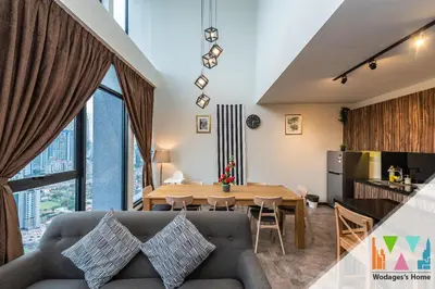 a living room with a couch and a table at KLCC View Expressionz Family Loft by WGS in Kuala Lumpur