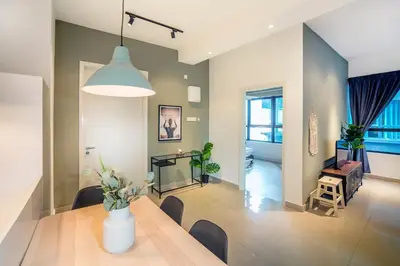 a dining room and living room with a table and chairs at Arte Plus KLCC Designer Suites by Cobnb in Kuala Lumpur