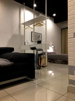a living room with a tv and a couch and a bed at 7 mins KLCC next to Hospital Gleneagle in Kuala Lumpur