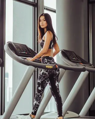 a woman standing on a treadmill in a gym at WGS Suites at KLCC in Kuala Lumpur