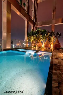 a swimming pool on top of a building at night at Tropicana The Residences KLCC by Vale Pine in Kuala Lumpur