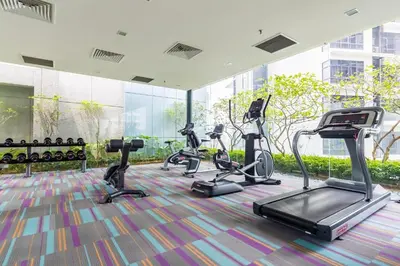 a gym with several treadmills and elliptical machines at Amethyst KLCC in Kuala Lumpur