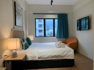 a bedroom with a bed and a chair and a window at Urban Living Residence in Kuala Lumpur