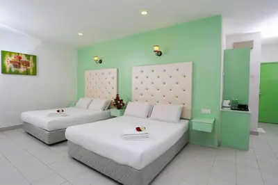 two beds in a room with green and white at Akar Hotel Kampung Baru in Kuala Lumpur