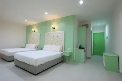 two beds in a room with green walls at Akar Hotel Kampung Baru in Kuala Lumpur