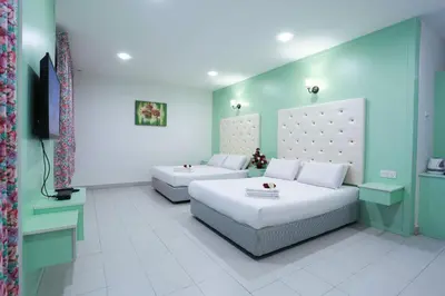 a bedroom with two beds and a television in it at Akar Hotel Kampung Baru in Kuala Lumpur