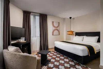 a hotel room with a large bed and a chair at BRYQS Hotel in Kuala Lumpur